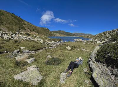 photograph “VIII.2023 — Last memory before electrocution” par David Farreny — www.farreny.net — France, Occitanie, Pyrénées-Orientales, Porta, Pyrénées, Pyrenees, montagne, mountain, paysage, landscape, herbe, grass, été, summer, lac, lake, estany de Font negra, lac de la Source noire, estany de les Abelletes, lac des Abeilles, eau, water, femme, woman, randonneuse, hiker, promeneuse, walker, allongée, lying down, sieste, nap, sommeil, sleep, chapeau, hat, rochers, rocks, nuage, cloud, ciel, sky, carte postale, postcard, É*