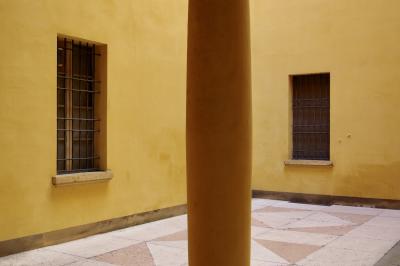 photograph “X.2019” par David Farreny — www.farreny.net — Italie, Italia, Italy, Émilie-Romagne, Emilia-Romagna, Bologne, Bologna, ville, city, bâtiment, building, cour, courtyard, yard, fenêtres, windows, grilles, railings, pierre, stone, colonne, column, pilier, pillar, jaune, yellow, coin, corner, angle