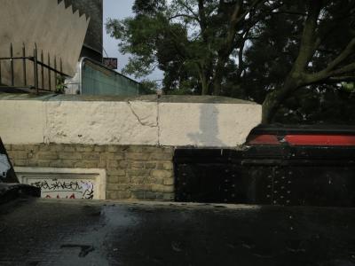 photograph “VIII.2015 — Whatever” par David Farreny — www.farreny.net — Royaume-Uni, United Kingdom, Grande-Bretagne, Great Britain, Angleterre, England, GB, UK, Londres, London, Camden, Camden Town, Regent's canal, brique, brick, muret, low wall, clôture, fence, barrière, fencing, métal, metal, rivets, arbre, tree, branches, branchages, feuillage, foliage, bois, wood, pont, bridge, tag, graffiti, ombre, shadow, profusion