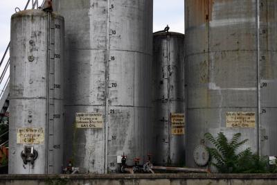 photograph “VII.2005” par David Farreny — www.farreny.net — France, Aquitaine, Corrèze, Brive-la-Gaillarde, Brive, gare, station, train, ferroviaire, cuves, tanks, citernes, cisterns, métal, metal, rouille, rust, rusty, cylindres, cylinders, échelle, ladder, marches, steps, rampe, banister, panneaux, boards, liquide inflammable, flammable liquid, gasoil, diesel, fuel, carburant, tuyaux, pipes, robinets, faucets, plante, plant, muret, low wall, ciment, cement, nombres, numbers, volume, litres, liters, vieux, old