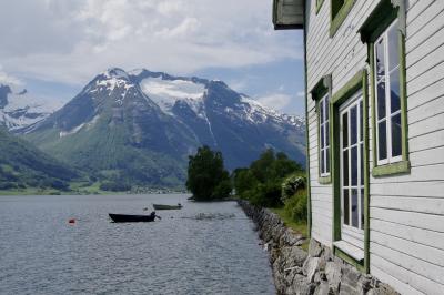 photograph “VI.2019 — Run away to the North, 143” par David Farreny — www.farreny.net — Norvège, Norway, Norge, Sogn og Fjordane, Stryn, Hjelle, Oppstrynsvatnet, Strynsvatnet, lac, lake, montagne, mountain, neige, snow, eau, water, bateaux, boats, barques, small boats, maison, house, bois, wood, planches, planks, fenêtres, windows, blanc, white, rive, shore, arbres, trees, paysage, landscape, bouée, buoy, carte postale, postcard