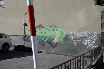 photograph “X.2021” par David Farreny — www.farreny.net — Andorre, Andorra, La Massana, ville, city, parking, car park, mur, wall, paroi, béton, concrete, immeuble, bâtiment, building, balcon, balcony, linge, laundry, gris, grey, gray, voiture, car, câbles, cables, fils, wires, rambarde, guardrail, barrière, métal, metal, poteau, post, pole, pierre, stone, bitume, blacktop, asphalt, asphalte, ombre, shadow, rouge, red, blanc, white, graffiti, tag, peinture, painting, illustration, moche, ugly, laideur, laid, ugliness