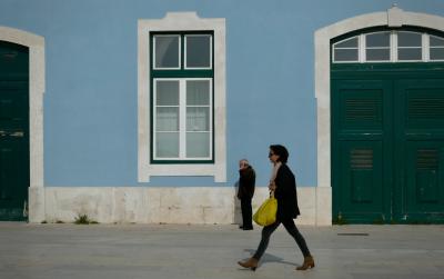 photograph “II.2020 — Accidentology” par David Farreny — www.farreny.net — Portugal, Lisbonne, Lisboa, Lisbon, rue, street, immeuble, building, trottoir, pavement, ville, city, capitale, capital, passants, passers-by, piétons, pedestrians, homme, man, vieux, old, femme, woman, sac, bag, jaune, yellow, téléphone, mobile, phone, chauve, bald, fenêtre, window, portail, gate, porte, door, pierre, stone, vert, green, verre, vitre, glass, bois, wood