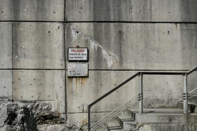 photograph “VII.2019 — At the port” par David Farreny — www.farreny.net — Espagne, Spain, España, Asturies, Asturias, Llanes, port, paroi, mur, wall, quai, quay, béton, concrete, escalier, staircase, marches, steps, rampe, ramp, métal, metal, rocher, rock, panneaux, signs, peligro, danger, rebase de agua con temporales, débordement d'eau lors de tempêtes, overflow of water with storms, no se responde de acidentes, aucune responsabilité en cas d'accident, no responsibility for accidents