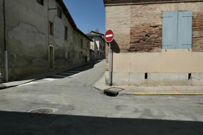 photograph “IV.2025 — Heatwave overview” par David Farreny — www.farreny.net — France, Occitanie, Gascogne, Gascony, Lomagne, Tarn-et-Garonne, Beaumont-de-Lomagne, rue, street, trottoir, pavement, murs, walls, brique, brick, fenêtres, windows, volets, shutters, bois, wood, panneau, sign, routier, roadsign, sens interdit, one way, ombres, shadows, métal, metal, bitume, blacktop, asphalte, asphalt, maisons, houses