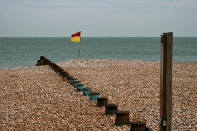 photograph “VII.2010” par David Farreny — www.farreny.net — Royaume-Uni, United Kingdom, Angleterre, England, GB, UK, Sussex, Eastbourne, paysage, landscape, seascape, Manche, Channel, mer, sea, côte, coast, plage, beach, horizon, gravier, gravel, épi, groyne, brise-lames, breakwater, galets, shingle, drapeau, flag, robinet, tap, faucet, poteau, post, rouge, red, jaune, yellow, mouette, gull, seagull