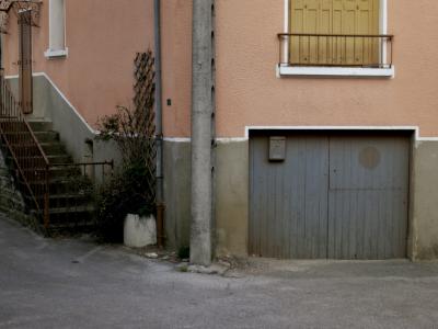 photograph “XI.2014 — Faces of home, 86” par David Farreny — www.farreny.net — France, domicile, home, maison, house, village, rue, street, poteau, post, pole, garage, portail, gate, fenêtre, window, volets, shutters, bois, wood, ciment, cement, treillis, trellis, marches, steps, escalier, stairs, perron, porte, door, rampe, banister, métal, metal, ligne, line, blanche, white, boîte à lettres, letterbox, mailbox, gouttière, drainpipe, Occitanie, Aveyron, Rouergue, Laissac