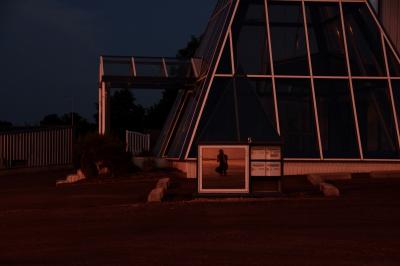photograph “VI.2014 — At night” par David Farreny — www.farreny.net — France, Occitanie, Aveyron, Rouergue, Olemps, nuit, night, zone industrielle, industrial zone, bâtiment, immeuble, building, pyramide, pyramid, métal, metal, verre, vitre, glass, boîtes à lettres, mailboxes, boîtier, box, miroir, mirror, reflet, reflection, homme, man, autoportrait, selfportrait, plaque, plate, numéro, number, 5, porche, porch, parkin, car park, bitume, blacktop, asphalte, asphalt, paroi, mur, wall, tôle ondulée, corrugated iron