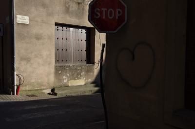 photograph “II.2014” par David Farreny — www.farreny.net — France, croisement, carrefour, crossroads, junction, stop, panneau, roadsign, rue, street, ville, city, fenêtre, window, volets, shutters, métal, metal, plaque, plate, gouttière, drainpipe, trottoir, pavement, cœur, heart, graffiti, mur, wall, ciment, cement, tube, tubing, tuyau, câbles, cables, fils, wires, hiver, winter, Occitanie, Aveyron, Rouergue, Réquista