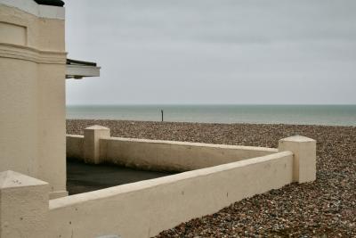 photograph “V.2013” par David Farreny — www.farreny.net — Royaume-Uni, United Kingdom, Grande-Bretagne, Great Britain, Angleterre, England, UK, GB, Sussex, West Sussex, Worthing, front de mer, seafront, plage, beach, galets, pebbles, shingle, mer, sea, Manche, Channel, horizon, eau, water, paysage, landscape, marin, seascape, bâtiment, building, muret, low wall, terrasse, terrace