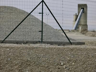 photograph “III.2012” par David Farreny — www.farreny.net — France, industrie, industry, usine, factory, béton, concrete, tas, heap, pile, gravier, gravel, cailloux, stones, grillage, clôture, fence, fencing, rampe, ramp, slope, tapis roulant, convoyeur à bande, conveyor belt, tour, tower, talus, bank, embankment, métal, metal, triangles, pyramide, pyramid, Aveyron, Occitanie, Sébazac-Concourès, Rouergue