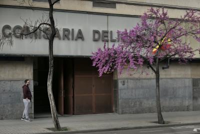 photograph “III.2023 — Delicias” par David Farreny — www.farreny.net — Espagne, España, Spain, Aragón, Aragon, Saragosse, Zaragoza, Caesaraugusta, ville, city, bâtiment, immeuble, building, béton, concrete, arbres, trees, troncs, trunks, trottoir, pavement, rue, street, fleurs, flowers, drapeau, flag, enseigne, sign, Comisaría Delicias, commissariat, police, station, homme, man, piéton, pedestrian, jeune, young, entrée, entrance, dallage, paving, bitume, blacktop, asphalte, asphalt, grille, fence, métal, metal, câbles, cables, fils, wires