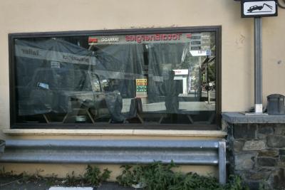 photograph “X.2023” par David Farreny — www.farreny.net — Andorre, Andorra, Canillo, mur, wall, baie, window, fenêtre, vitrine, magasin, shop, store, verre, vitre, glass, reflet, reflection, garage, station-service, gas station, enseigne, sign, TotalEnergies, Tarrado, pneumàtics, taller, pneumatiques, voiture, car, prix, prices, essence, carburant, gas, homme, man, photographe, photographer, glissière, sécurité, crash, barrier, métal, metal, pierre, stone, panneau, plantes, plants
