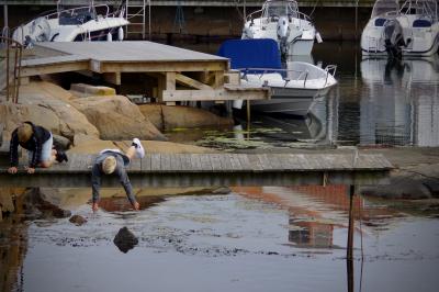 photograph “VIII.2019 — Run away to the North, 158” par David Farreny — www.farreny.net — Suède, Sweden, Sverige, Bohuslän, Västra, Götaland, Sotenäs, Smögen, bourgade, town, village, port, harbour, quai, quay, bateaux, boats, ponton, pontoon, bois, wood, eau, water, rochers, rocks, échelle, ladder, enfants, children, blonds, blond, jeu, game, enfance, childhood, fil de fer, wire, baskets, sneakers, reflet, reflection, summer, été