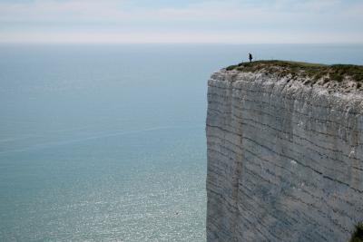 photograph “V.2013 — Resign” par David Farreny — www.farreny.net — Royaume-Uni, United Kingdom, Angleterre, England, GB, UK, Sussex, East Sussex, Eastbourne, Beachy Head, cap, Béveziers, falaise, cliff, promontoire, cape, headland, craie, chalk, mer, sea, Channel, Manche, horizon, herbe, grass, suicide, suicide spot, paysage, landscape, seascape, eau, water, homme, man, personnage, figure, carte postale, postcard, bouée, buoy, clôture, fence, bleu, blue