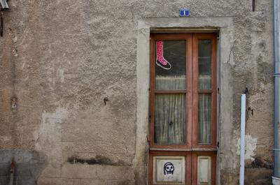 photograph “III.2014” par David Farreny — www.farreny.net — France, porte, door, mur, wall, ciment, cement, verre, vitre, glass, autocollants, stickers, jambe, leg, pied, foot, chaussure, shoe, rideau, curtain, gouttière, drainpipe, métal, metal, bois, wood, Occitanie, Aveyron, Rouergue, Rignac