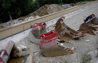 photograph “VI.2023” par David Farreny — www.farreny.net — Andorre, Andorra, Canillo, chantier, construction site, route, road, voie, way, béton, concrete, sol, soil, terre, earth, pelles, shovels, métal, metal, rouille, rust, rusty, pierres, stones, cailloux, pebble, arbres, trees, perspective, bouteilles, bottles, plastique, plastic