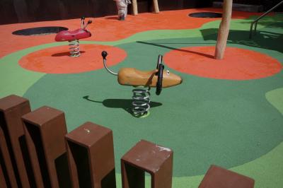 photograph “VI.2023” par David Farreny — www.farreny.net — Andorre, Andorra, Canillo, aire de jeux, playground, colorée, coloured, colored, barrière, fence, métal, metal, jeux, games, animaux, animals, chien, dog, coccinelle, ladybug, ressorts, springs, sol, artificiel, artificial, troncs, trunks, ground, vert, green, orange, ombres, shadows