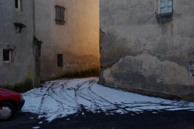 photograph “II.2015” par David Farreny — www.farreny.net — France, maisons, houses, murs, walls, ciment, cement, fenêtres, windows, lumière, light, passage, allée, alley, neige, snow, traces, tracks, voiture, car, rouge, red, village, Occitanie, Aveyron, Rouergue, Olemps