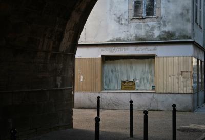 photograph “III.2012” par David Farreny — www.farreny.net — France, pont, bridge, ville, city, salon, coiffure, hairdressing, magasin, shop, store, coiffeur, hairdresser, devanture, window, enseigne, sign, Coiffure dames, dames, ladies, fermé, closed down, à vendre, for sale, volets, shutters, bois, wood, poteaux, posts, métal, metal, pierre, stone, ciment, cement, vitrine, panneau, badigeon, whitewash, lait de chaux, blanc d'Espagne, whiting, whitening, trottoir, pavement, rue, street, arche, arch, Occitanie, Rouergue, Aveyron, Espalion