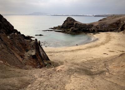 photograph “II.2018 — Lancerotte, 80” par David Farreny — www.farreny.net — Espagne, Spain, España, Canaries, Canarias, Lanzarote, Lancerotte, Yaiza, Papagayo, île, island, plage, beach, mer, sea, océan, ocean, Atlantique, Atlantic, rivage, seashore, eau, water, rochers, rocks, promeneurs, walkers, baie, bay, cailloux, stones, sable, sand, ville, city, Playa Blanca, montagne, mountain, horizon