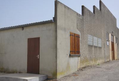 photograph “III.2021 — Municipal achievements, 10. Dojo” par David Farreny — www.farreny.net — France, bâtiment, building, immeuble, béton, concrete, ciment, cement, portes, doors, bois, wood, fenêtres, windows, volets, shutters, lampe, lamp, fronton, gouttière, gutter, rue, street, village, bitume, blacktop, asphalte, asphalt, poignée, handle, métal, metal, verre, glass, dojo, salle, sport, hall, laid, ugly, laideur, ugliness, coin, corner, angle, tuiles, tiles, Occitanie, Gascogne, Gers, Valence-sur-Baïse