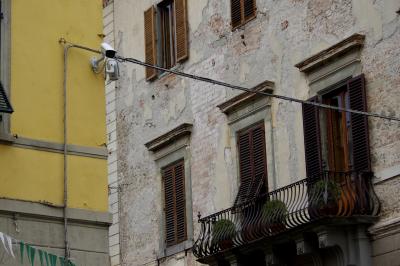 photograph “X.2019 — Faces of home, 200” par David Farreny — www.farreny.net — Italie, Italia, Italy, Toscane, Toscana, Tuscany, Pistoia, Pistoie, ville, city, rue, street, murs, walls, fenêtres, windows, volets, shutters, bois, wood, métal, metal, câbles, cables, fils, wires, caméras, cameras, vidéo, video, balcon, balcony, rambarde, guardrail, brique, brick, pierre, stone, angle, coin, corner, domicile, home