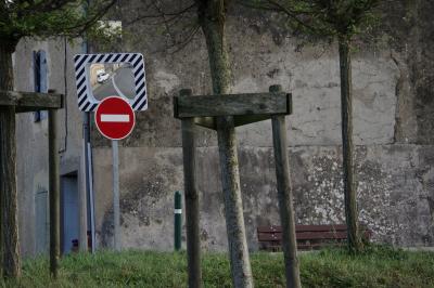 photograph “XI.2015” par David Farreny — www.farreny.net — France, Occitanie, Gascogne, Gascony, Gers, Jegun, arbres, trees, troncs, trunks, village, mur, wall, maison, house, banc, bench, fenêtre, window, porte, door, angle, coin, corner, panneau, routier, sign, roadsign, sens interdit, one way, herbe, grass, miroir, mirror, voiture, car, feuilles, leaves, volets, bois, wood, métal, metal, poteau, post, pole, profusion