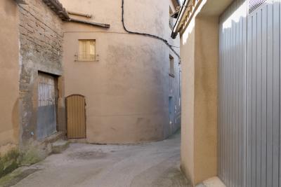 photograph “XII.2021 — Faces of home, 131” par David Farreny — www.farreny.net — Espagne, España, Spain, Aragon, Aragón, Huesca, Somontano de Barbastro, Colungo, village, rue, street, murs, walls, pierre, stone, béton, concrete, ruelle, alley, garage, portail, gate, métal, metal, gouttières, drainpipes, portes, doors, fenêtres, windows, volets, shutters, bois, wood, câble, cable, fil, wire, mousse, moss, humidité, dampness, marche, step, tuiles, tiles, domicile, home