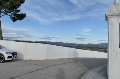 photograph “I.2022” par David Farreny — www.farreny.net — Espagne, España, Espanya, Spain, Catalogne, Cataluña, Catalunya, Alt Empordà, Gérone, Girona, Gerona, Figueres, Figueras, Figuières, Sant Ferran, château, castle, route, roas, montée, coast, mur, wall, blanc, white, voiture, car, arbre, tree, pin, pine, paysage, landscape, montagnes, mountains, plaine, plain, ombre, shadow, ciel, sky, hiver, winter, trottoir, pavement, nuages, clouds