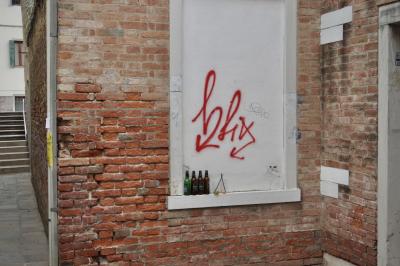 photograph “V.2022” par David Farreny — www.farreny.net — Italie, Italia, Italy, Vénétie, Veneto, Venise, Venice, Venezia, Venexia, bâtiments, immeubles, buildings, mur, wall, brique, brick, fenêtres, windows, rue, street, ruelle, alley, coin, angle, corner, peinture, paint, métal, metal, tag, graffiti, gouttière, drainpipe, hlix, hfix, bouteilles, bottles, bière, beer, verre, glass, verres, glasses, béton, concrete, marches, steps, escalier, staircase, volet, shutter, bois, wood, flèches, arrows