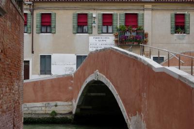 photograph “V.2022 — Faces of home, 168” par David Farreny — www.farreny.net — Italie, Italia, Italy, Vénétie, Veneto, Venise, Venice, Venezia, Venexia, Sant'Alvise, parrocchia, paroisse, parish, San Bonaventura, ponte, pont, bridge, mur, wall, brique, brick, maison, house, façade, facade, fenêtres, windows, volets, shutters, bois, wood, rambarde, guardrail, métal, metal, gouttière, drainpipe, câbles, cables, fils, wires, lampe, lamp, porte, door, arche, arc, arch, pierre, stone, balcon, balcony, fleurs, flowers, pots, toit, roof, tuiles, tiles, panneau, sign, domicile, home
