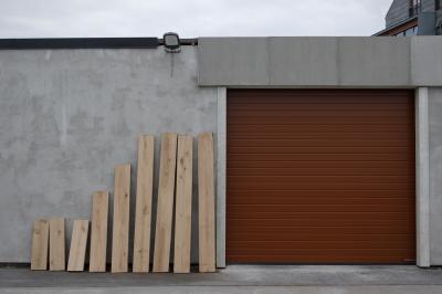 photograph “VI.2019 — Run away to the North, 145. Hordaland (det.)” par David Farreny — www.farreny.net — Norvège, Norway, Norge, Hordaland, Austevoll, Bekkjarvik, garage, portail, gate, métal, metal, bâtiment, building, béton, concrete, projecteur, floodlight, lampe, lamp, planches, planks, bois, wood, neuf, nine, 9