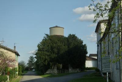 photograph “IV.2025 — Decency” par David Farreny — www.farreny.net — France, Occitanie, Gascogne, Gascony, Lomagne, Gers, Tournecoupe, village, maisons, houses, rues, streets, château d'eau, water tower, pierre, stone, béton, concrete, tête, head, sommet, top, arbres, trees, paroi, wall, panneaux, signs, routiers, roadsigns, voiture, car, haie, hedge, antenne, antenna, toits, roofs, tuiles, tiles, gouttières, drainpipes, métal, metal, volets, shutters, bois, wood, nuages, clouds, lampe, lamp, muret, low wall, Ammanaud, La Bordeneuve, Ensentis, Embernie Saint-Paul, Canteperdrix, Enjoinques, Jouandebans, Navasse