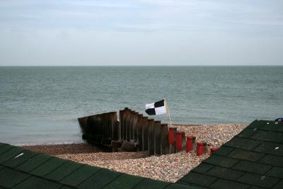 photograph “VII.2010” par David Farreny — www.farreny.net — Royaume-Uni, United Kingdom, Angleterre, England, GB, UK, Sussex, Eastbourne, paysage, landscape, seascape, Manche, Channel, sea, côte, coast, plage, beach, gravier, gravel, épi, groyne, brise-lames, breakwater, galets, shingle, baigneurs, swimmers, bathers, vacanciers, holidaymakers, vacationers, cabines, bain, bathing, huts, toits, roofs, drapeau, flag, horizon, damier, check, tuiles, tiles