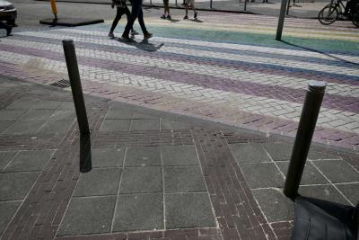 photograph “VI.2018” par David Farreny — www.farreny.net — Pays-Bas, Netherlands, Nederland, Hollande, Holland, Hollande-Septentrionale, Zandvoort, rue, street, passage piétons, pedestrian crossing, zebra, cyclistes, cyclists, bicyclettes, bicycles, vélos, bikes, piétons, passers-by, passants, pedestrians, poteaux, posts, poles, métal, trottoir, pavement, pierre, stone, dallage, paving, voiture, car, ombre, shadow