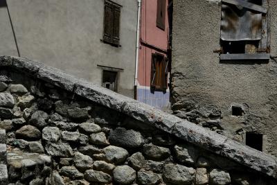 photograph “VI.2020 — Faces of home, 107” par David Farreny — www.farreny.net — Espagne, Spain, España, Catalogne, Catalonia, Cataluña, Catalunya, Catalonha, Lérida, Lleida, Aran, Val d'Aran, Bossòst, village, bourgade, rue, street, pierre, stone, rampe, ramp, maisons, houses, ciment, cement, gris, grey, gray, murs, walls, fenêtres, windows, porte, door, gouttière, drainpipe, métal, metal, fils, wires, câbles, cables, abandonné, abandoned, angle, coin, corner, ombre, shadow, domicile, home, Vielha, Vielha e Mijaran