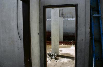 photograph “III.2007” par David Farreny — www.farreny.net — France, Occitanie, Aveyron, Rouergue, Rodez, chantier, works, construction site, immeuble, bâtiment, building, béton, concrete, porte, door, murs, walls, piliers, pillars, structure, métal, metal, tuyaux, pipes, flaques, flasks, eau, water