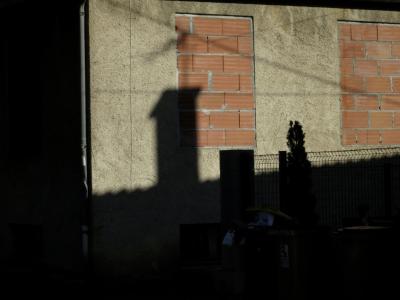 photograph “XII.2016 — So it\'s no” par David Farreny — www.farreny.net — France, Occitanie, Gascogne, Gers, Auch, mur, wall, fenêtres, windows, murées, bricked up, briques, bricks, ombre, shadow, cheminée, chimney, câbles, cables, fils, wires, grillage, clôture, fence, gouttière, drainpipe