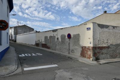 photograph “III.2023” par David Farreny — www.farreny.net — Espagne, España, Spain, Aragón, Aragon, Saragosse, Zaragoza, Ribera Alta del Ebro, Alagón, ville, city, rue, street, carrefour, crossroads, bitume, blacktop, asphalte, asphalt, mur, wall, angle, coin, corner, stop, panneaux, routiers, signs, roadsigns, métal, metal, cement, ciment, ciel, sky, nuages, clouds, maisons, houses, fenêtres, windows, porte, door, trottoir, pavement, toits, roofs, graffiti, tag, IRA, plaque, plate, flèche, arrow, antenne, antenna, chimneys, cheminées