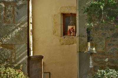 photograph “III.2025 — Faces of home, 279” par David Farreny — www.farreny.net — France, Occitanie, Tarn-et-Garonne, Caylus, village, maison, house, pierre, stone, entrée, entrance, porte, door, bois, wood, cloche, bell, lierre, ivy, fenêtre, window, panneau, sign, chien, dog, illustration, beware of dog, attention au chien, feuilles, leaves, feuillage, foliage, domicile, home