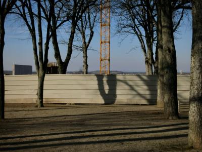 photograph “II.2012” par David Farreny — www.farreny.net — France, chantier, construction, site, arbres, trees, grue, crane, palissade, boarding, métal, metal, tôle ondulée, corrugated iron, jardin, public, garden, parc, park, ville, city, hiver, winter, soir, evening, troncs, trunks, ombres, shadows, Occitanie, Aveyron, Rouergue, Rodez