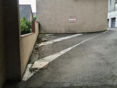 photograph “X.2014 — Waiting for Lucie” par David Farreny — www.farreny.net — France, Occitanie, Aveyron, Rouergue, Rodez, parking, car park, bitume, blacktop, asphalte, asphalt, coin, corner, mur, wall, panneau, sign, Défense de stationner, No parking, crépi, roughcast, peinture, paint, blanche, white, garages, portails, gates, béton, concrete, toit, roof, ardoise, slate, balcon, balcony, arbre, tree