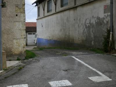 photograph “IV.2016” par David Farreny — www.farreny.net — France, rue, street, allée, alley, passage, croisement, crossing, bitume, blacktop, asphalte, asphalt, impasse, dead end, coin, corner, angle, pierre, stone, panneau, roadsign, sign, métal, metal, propriété privée, défense d'entrer, private property, no entry, gouttière, drainpipe, mur, wall, entrepôt, warehouse, trottoir, pavement, garage, toit, roof, tuiles, tiles, camionnette, van, portail, gate, béton, concrete, câbles, cables, fils, wires, herbe, grass, fenêtres, windows, grilles, railings, Occitanie, Gascogne, Gers, Auch