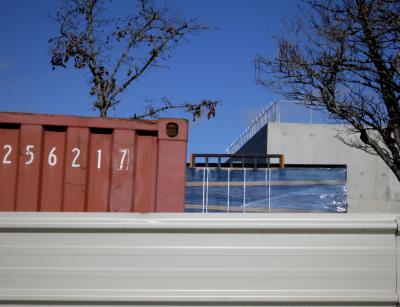 photograph “XI.2012” par David Farreny — www.farreny.net — France, Occitanie, Aveyron, Rouergue, Rodez, chantier, construction site, works, palissade, palisade, métal, metal, tôle ondulée, corrugated iron, conteneur, container, nombre, number, 256217, arbres, trees, panneaux, verre, vitre, glass, panels, boards, béton, concrete, balustrade, guardrail, rambarde, bâche, sheet, plastique, plastic, coin, angle, corner, ruban, adhésif, adhesive, tape, musée, Soulages, museum