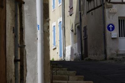 photograph “III.2021 — Faces of home, 171” par David Farreny — www.farreny.net — France, Aquitaine, Lot-et-Garonne, Nérac, ville, city, rue, street, maisons, houses, escalier, stairs, staircase, marches, steps, coin, corner, angle, panneau, sign, routier, roadsign, flèche, arrow, haut, up, tuyau, pipe, gouttière, drainpipe, portes, doors, fenêtres, windows, volets, shutters, bois, wood, boîte à lettres, mailbox, plaque, plate, place de la République, pierre, stone, ciment, cement, domicile, home, Gascogne, Gascony