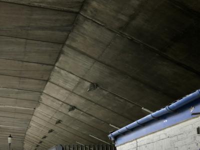 photograph “VIII.2015” par David Farreny — www.farreny.net — Grande-Bretagne, Great Britain, United Kingdom, Royaume-Uni, Angleterre, England, GB, UK, Londres, London, Kensington, Chelsea, Notting Hill, pont, bridge, béton, concrete, lampadaire, lamp, plafond, ceiling, bâtiment, building, brique, brick, blanc, white, gouttière, gutter, métal, metal, bleu, blue, grille, clôture, fence, câbles, cables, fils, wires, projecteurs, floodlights
