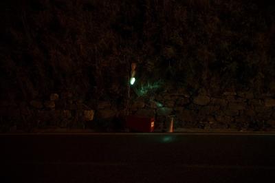 photograph “VII.2023 — At night” par David Farreny — www.farreny.net — Andorre, Andorra, Canillo, nuit, night, route, road, bitume, blacktop, asphalte, asphalt, feu rouge, red light, vert, green, cône, cone, plastique, plastic, orange, coffre, box, batterie, battery, métal, metal, ligne, line, peinture, paint, blanche, white, paroi, wall, colline, hill, végétation, vegetation, rochers, rocks