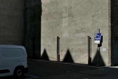 photograph “VI.2021” par David Farreny — www.farreny.net — Andorre, Andorra, Canillo, parking, car park, mur, wall, béton, concrete, gris, grey, gray, ombre, shadow, ombres, shadows, fourgonnette, van, minivan, voiture, car, véhicule, vehicle, panneau, sign, P, coin, corner, angle, pierre, stone, portail, gate, métal, metal, garage, bitume, blacktop, asphalte, asphalt, ville, city, bourgade, town