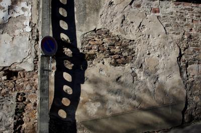 photograph “I.2014” par David Farreny — www.farreny.net — France, mur, wall, pierre, stone, enduit, coating, poteau, électrique, electricity, pole, ciment, cement, panneau routier, roadsign, interdiction de stationner, no parking, trous, holes, ombre, shadow, nombres, numbers, rue, street, Occitanie, Aveyron, Rouergue, Rodez, Combarel